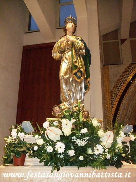08/12/2016. L'addobbo dei fiori bianchi attorno alla statua.