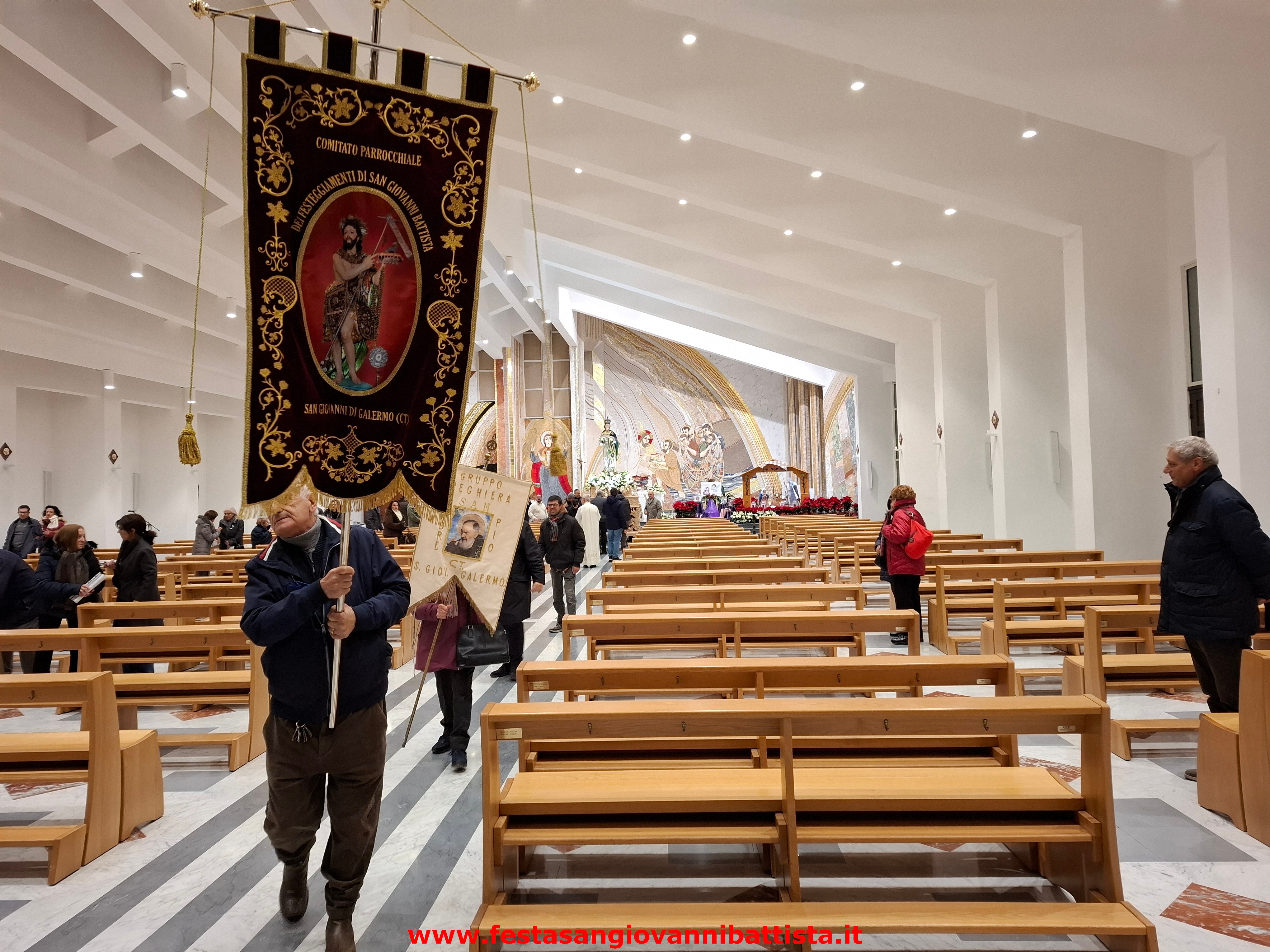 08/12/2024. L'uscita dello stendardo del comitato della festa San Giovanni Battista dalla chiesa segna l'inizio della processione.