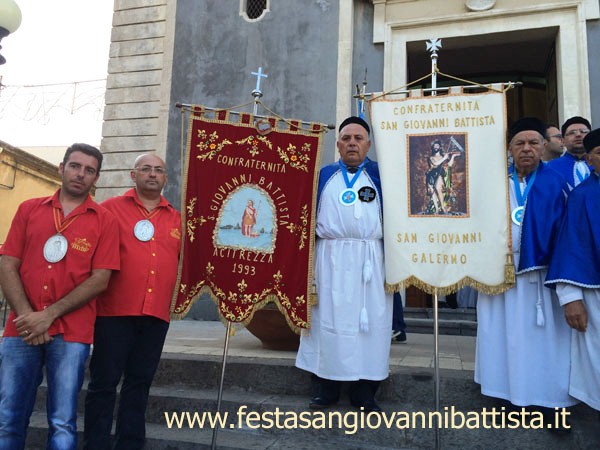 26/06/2016. Il confrate Pippo Di Mariano tra lo stendardo della confraternita di San Giovanni Battista di Aci Trezza (a sinistra) e lo stendardo della confraternita di San Gio.Battista di S.G. Galermo (a destra).