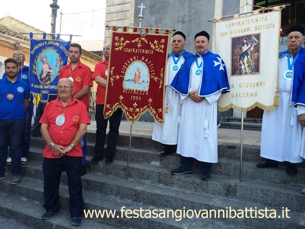 26/06/2016. I confrati Pippo Di Mariano e Vito Rapisarda tra lo stendardo della confraternita di San Giovanni Battista di Aci Trezza (a sinistra) e lo stendardo della confraternita di San Gio.Battista di S.G. Galermo (a destra).